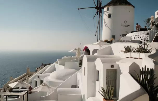 A white building made of a cascade and on top with a mill